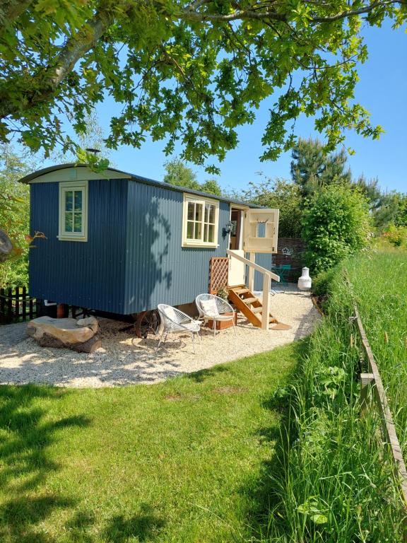 a tiny house with a dog sitting in front of it at The Humble Hut in Wooler