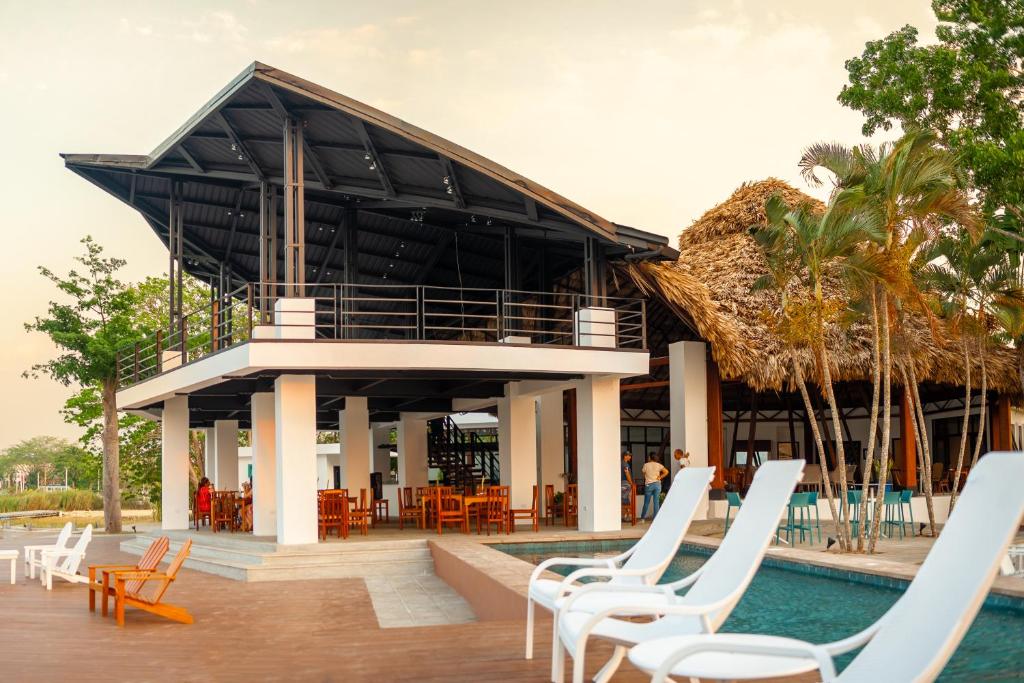 a resort with white chairs and a swimming pool at Hotel Maya Internacional in Flores