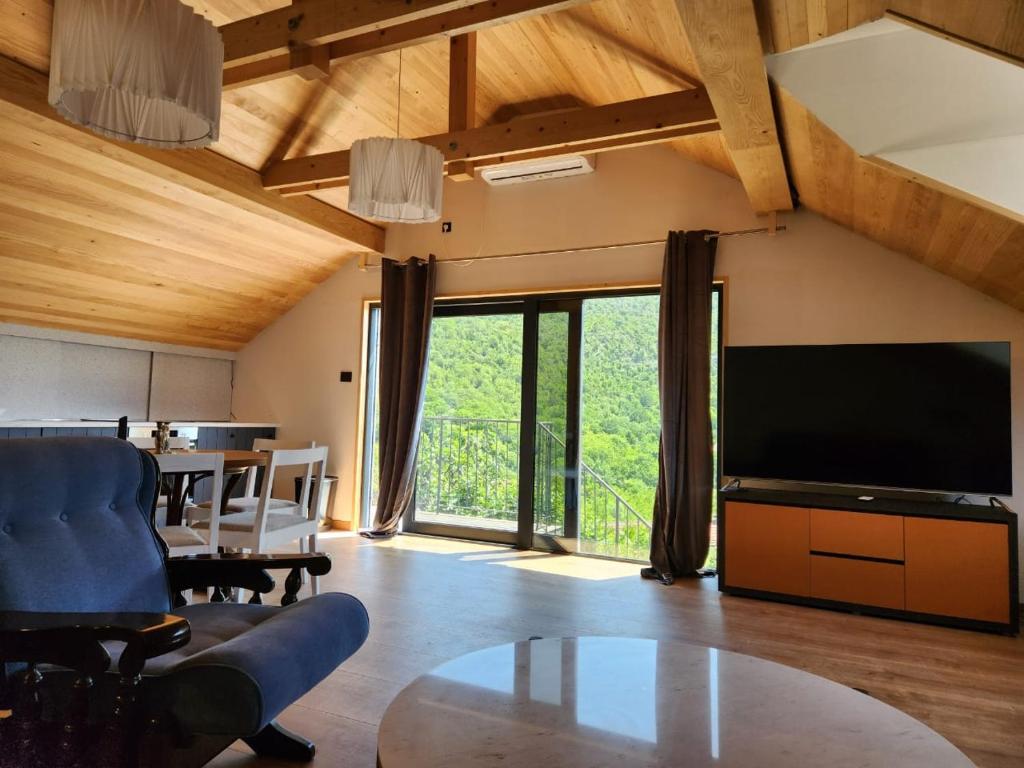 a living room with a large television and a table at Dodoši Ksenija in Cetinje