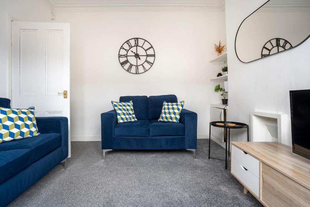 a living room with two blue couches and a tv at The Crown, Modern and Stylish Home from Home in Darlington
