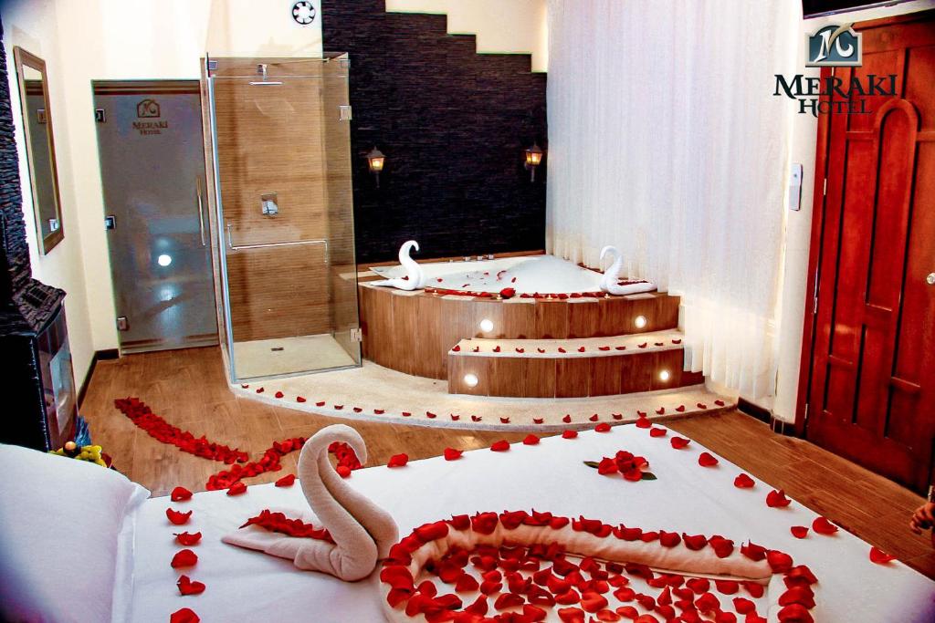 Habitación con bañera y pastel con rosas. en Meraki Hotel en Baños