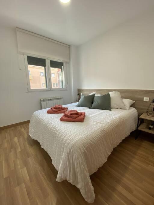 a bedroom with a large bed with two towels on it at Apartamento NyA Zamora in Zamora