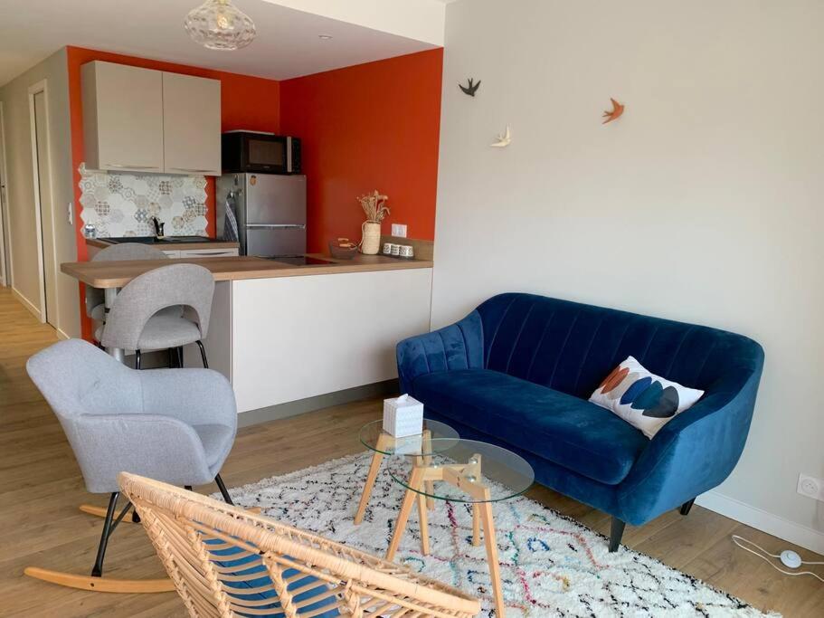 a living room with a blue couch and a kitchen at T2 avec garage possible, port et plage à moins de 5 minutes à pied ! in Bandol