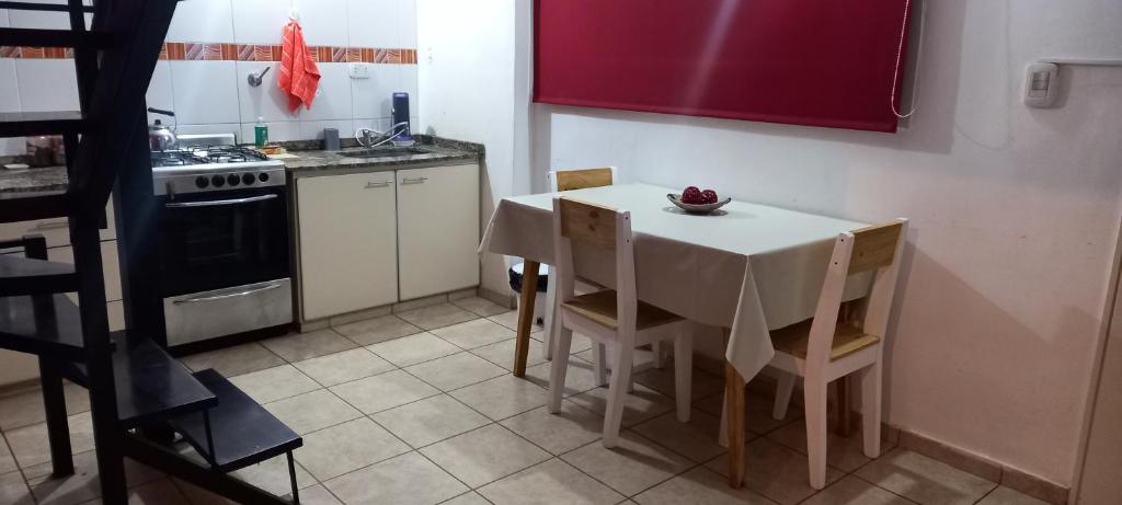 een keuken met een tafel en stoelen en een fornuis bij Dpto económico para tres en Ballester con TV in Villa Ballester