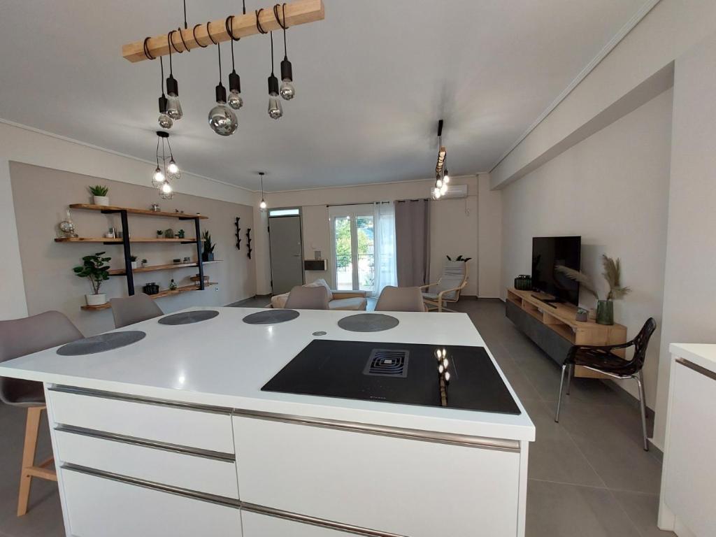 a kitchen with a white island in a living room at New minimal apartment,10' from Athens airport in Spata