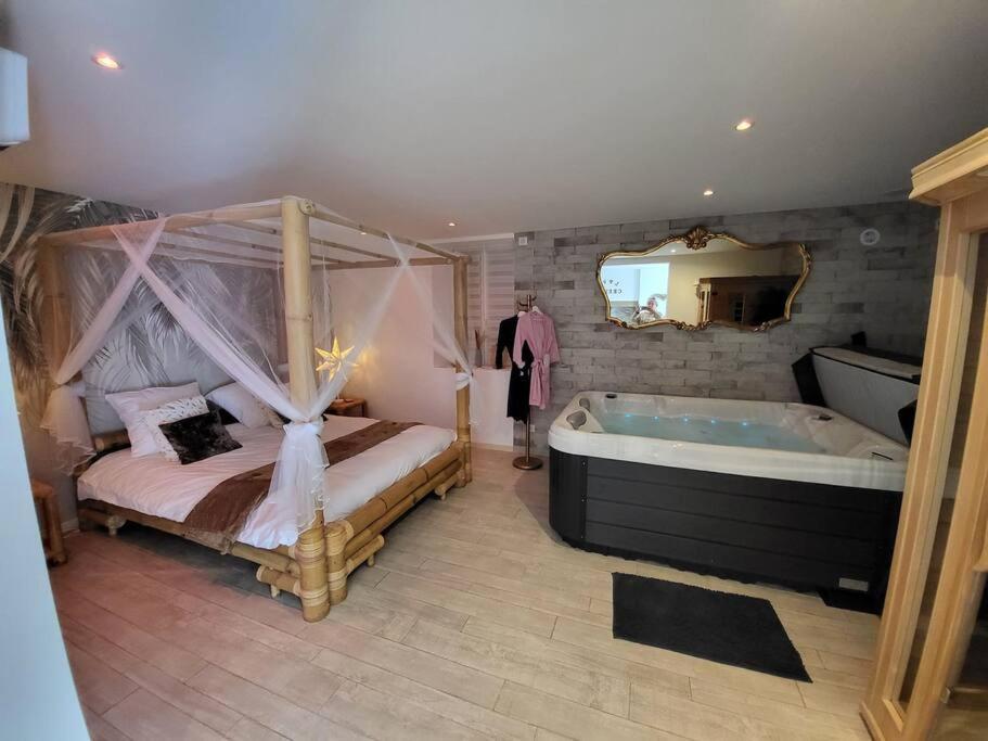 ein Schlafzimmer mit einem großen Bett und einer Badewanne in der Unterkunft Une petite maison seulement pour 2 