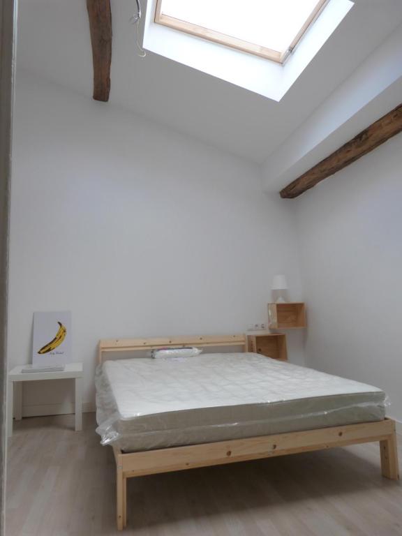 Cama en habitación blanca con ventana en San Antonio Suites Vitoria, en Vitoria-Gasteiz