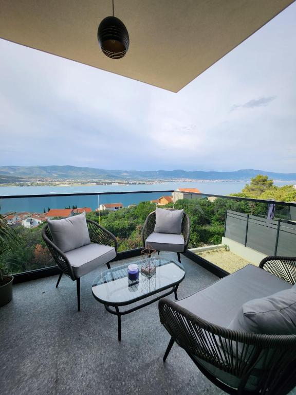a patio with chairs and a table and a view of the ocean at Feel Good View in Trogir