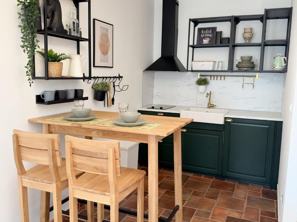 une cuisine avec des placards verts et une table et des chaises en bois dans l'établissement Apartments Melita, à Podstrana