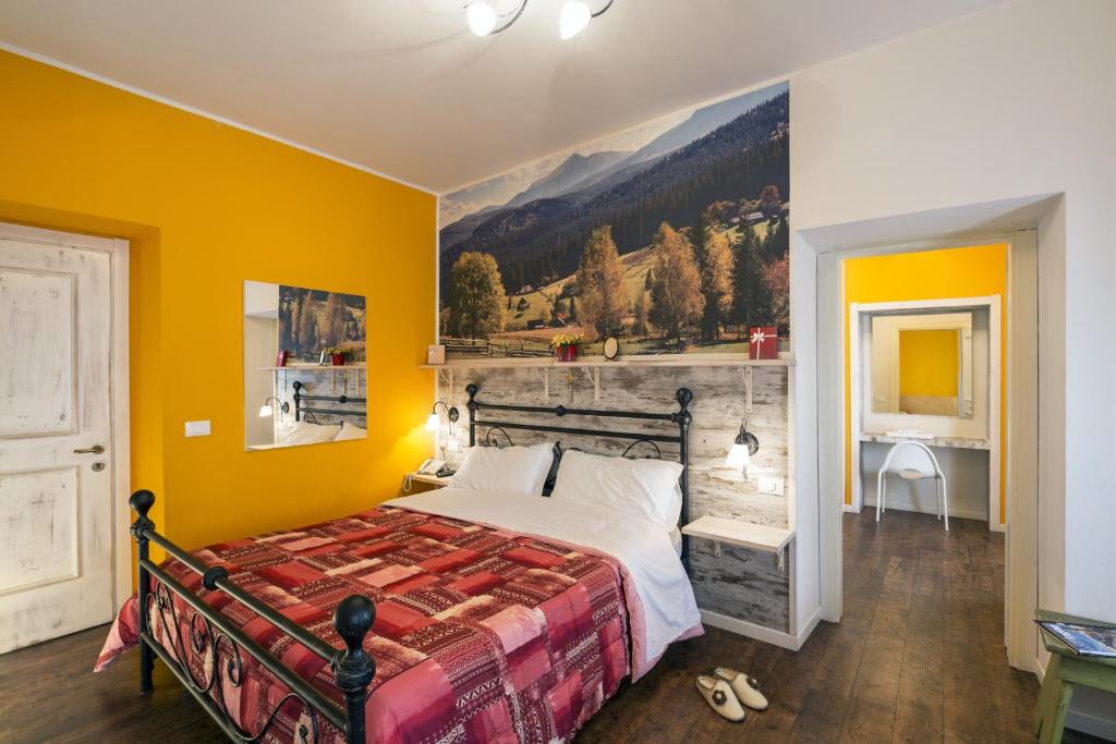 a bedroom with a bed with a painting on the wall at Albergo Garni Barancio in Auronzo di Cadore