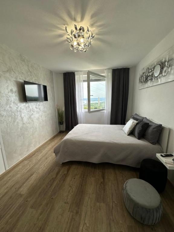 - une chambre avec un grand lit et un lustre dans l'établissement Apartmaji Meli Pu 2, à Izola