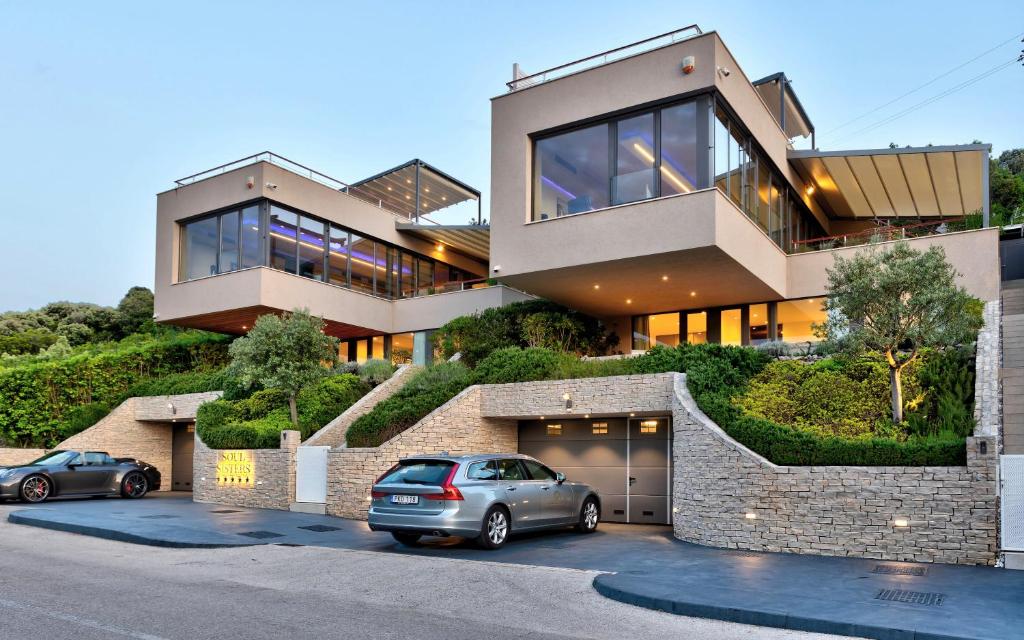 une maison avec deux voitures garées devant elle dans l'établissement Villa Soul Sisters, à Korčula