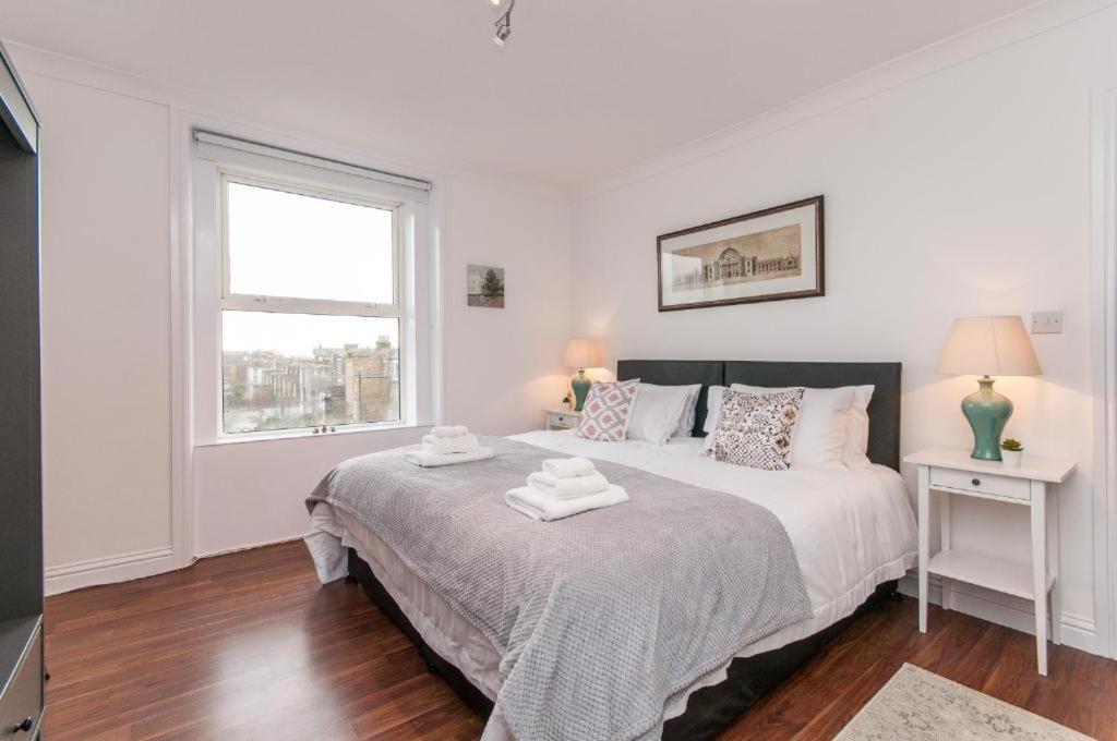 a white bedroom with a large bed and a window at Seaview Oasis - Margate Abode - Sleeps 4 in Kent
