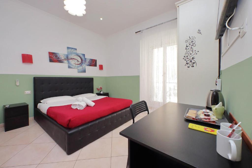 1 dormitorio con 1 cama con manta roja y escritorio en Dandi Domus en Roma