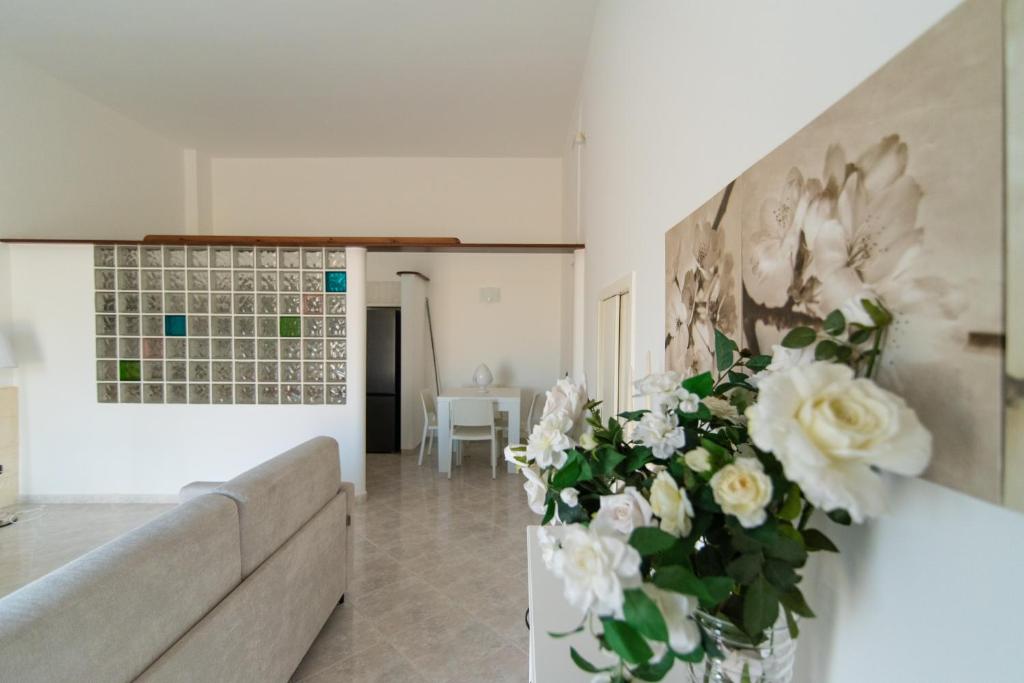 - un salon avec un canapé et un vase de fleurs dans l'établissement Dimora Azzurra, à Pezze di Greco