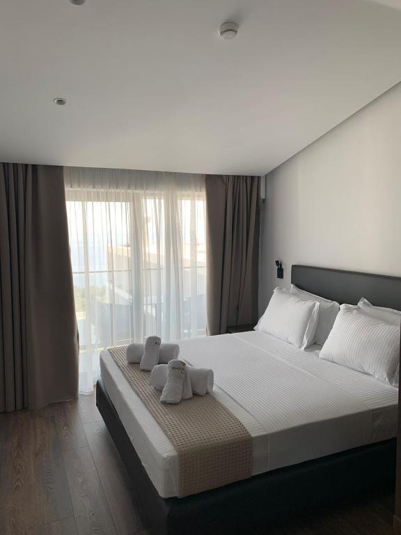 a bedroom with a large bed with towels on it at Black Diamond Hotel Dhermi in Dhërmi