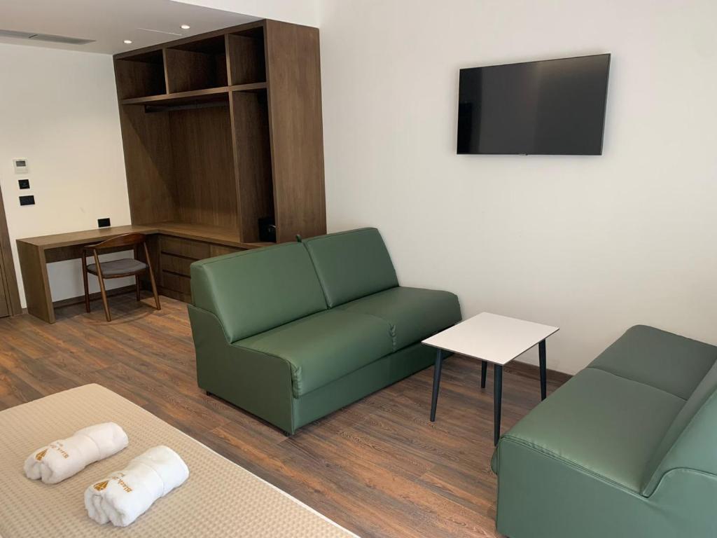 a living room with a couch and a tv at Black Diamond Hotel Dhermi in Dhërmi