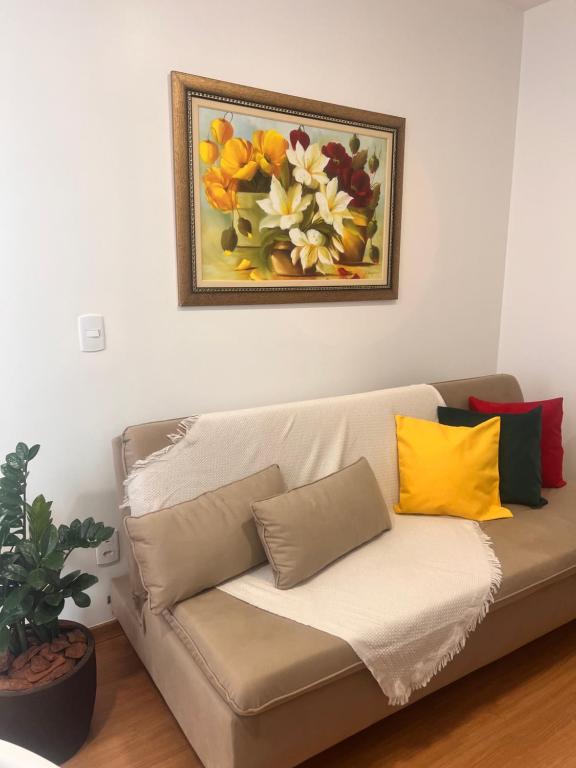um sofá numa sala de estar com um quadro na parede em Apto ao lado do Shopping Caruaru próximo ao pátio unidade 302 em Caruaru