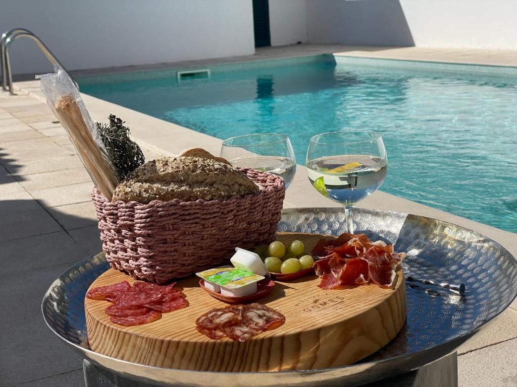 a table with a plate of food and a glass of wine at MHouse lease Comporta Nature Retreat 3BR Villa in Comporta