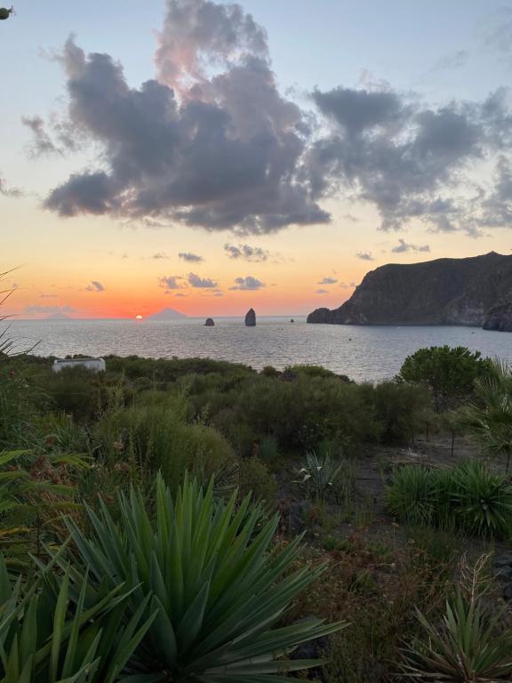 un coucher de soleil sur l'océan avec des îles au loin dans l'établissement Casa Vacanze Residence Baia Fenicia Vulcano, Isole Eolie, à La Fabbrica