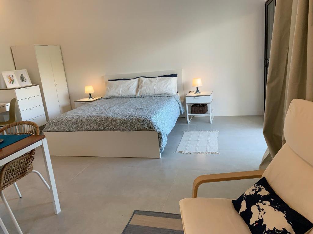 a bedroom with a bed and a table and a chair at Naturalis - Oceanview Residences in Mahe