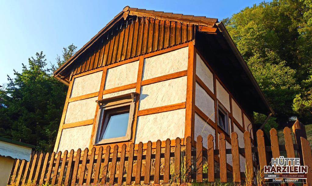 una pequeña casa detrás de una valla de madera en Arode Hütte Harzilein - Romantic tiny house on the edge of the forest, en Zorge