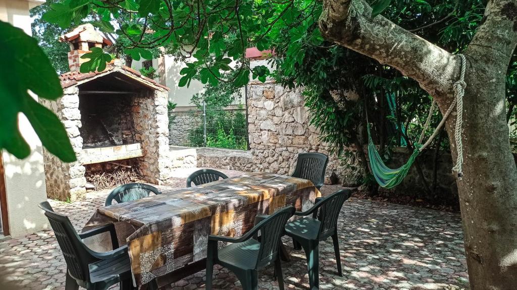 une table et des chaises dans une cour sous un arbre dans l'établissement Holiday Home Family - 100m from sea, à Vantačići