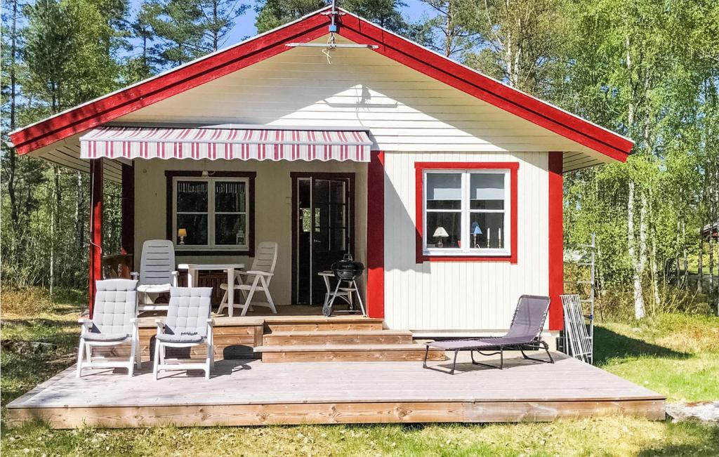 Casa pequeña de color rojo y blanco con sillas y mesa en Gorgeous Home In Herrng With Kitchen en Herräng