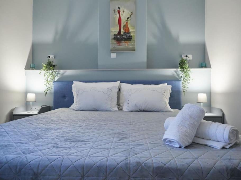 um quarto azul com uma cama grande e almofadas brancas em Casa di Andreo em Faraí