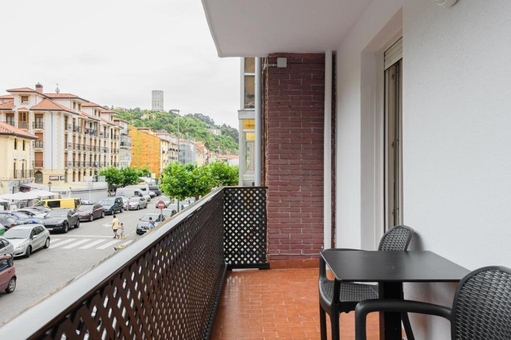 a balcony with a table and chairs and a city street at Vacacional in Laredo
