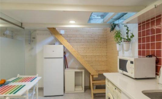 a kitchen with a white refrigerator and a staircase at Adelino apartamentos in Camarate