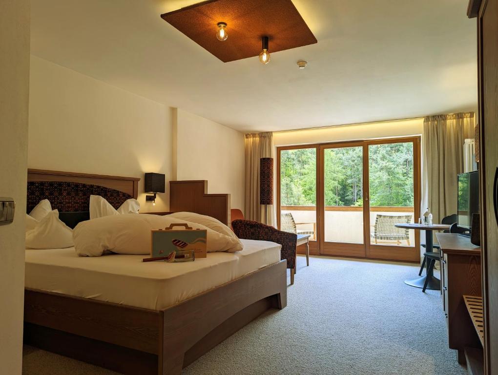 ソプラボルツァーノにあるHotel Weihrerhofのベッドとバルコニー付きのホテルルーム