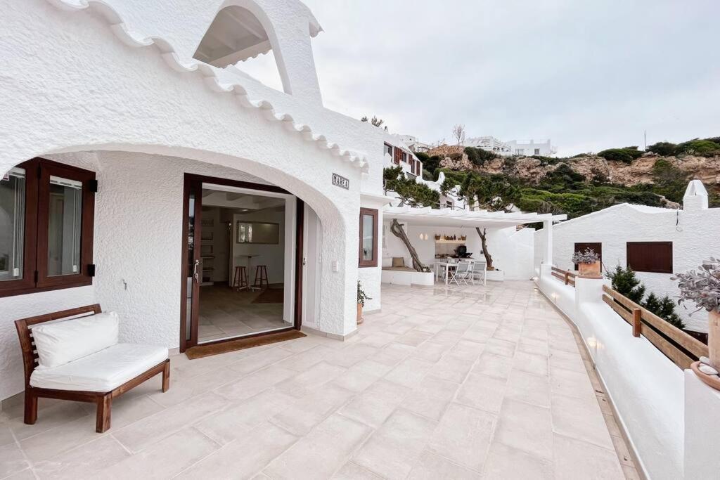 Casa blanca con patio con silla en Luxury House 80m2 Terrace en Cala Morell