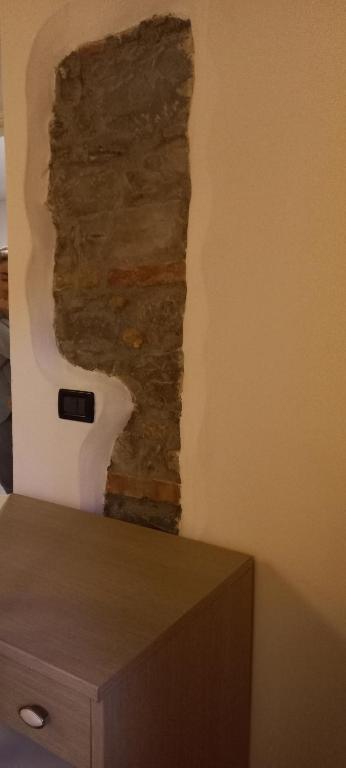 a wall with a stone wall next to a table at La casa delle fate in Lusevera