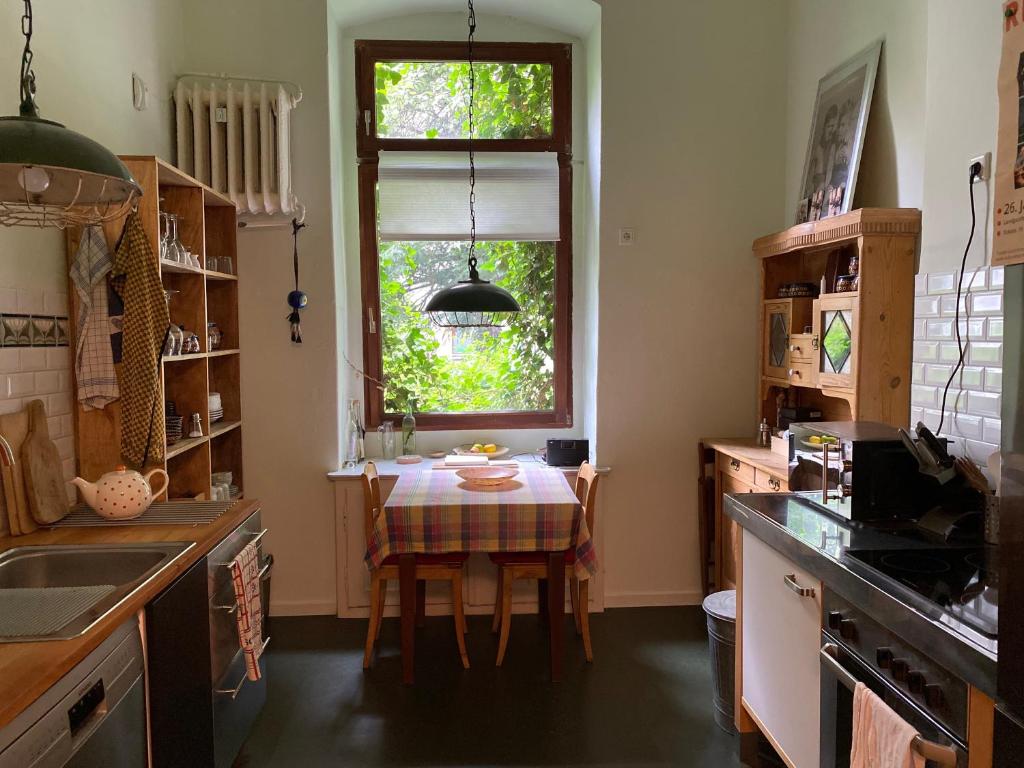 eine Küche mit einem Tisch und einem Fenster in der Unterkunft FeWo Grüne Mommsenstraße - bei Becker klingeln in Berlin
