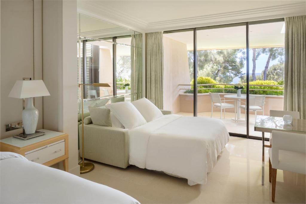 a white bedroom with a bed and a couch at Grand-Hôtel du Cap-Ferrat, A Four Seasons Hotel in Saint-Jean-Cap-Ferrat