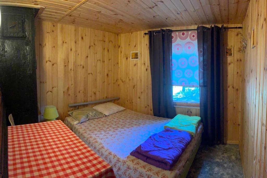 a small bedroom with a bed and a window at Дом на берегу Чудского озера in Katase