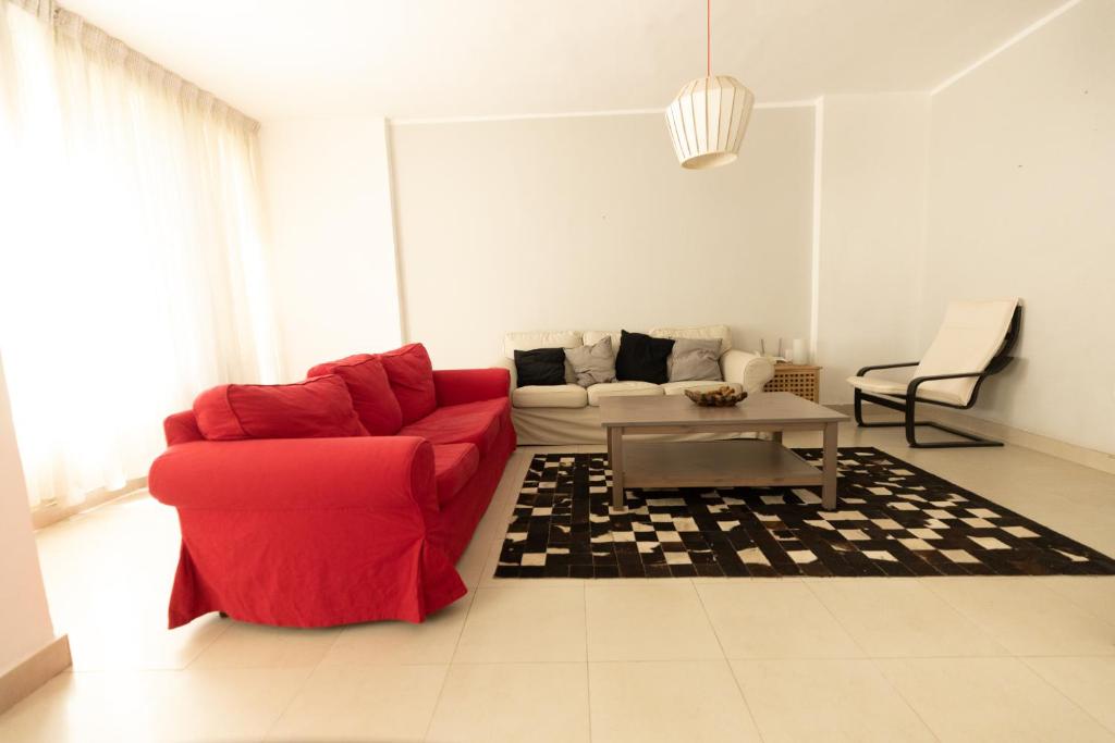 uma sala de estar com um sofá vermelho e uma mesa em Lily Mint Spacious 3BR Apt in Maadi W-TV and WIFI no Cairo