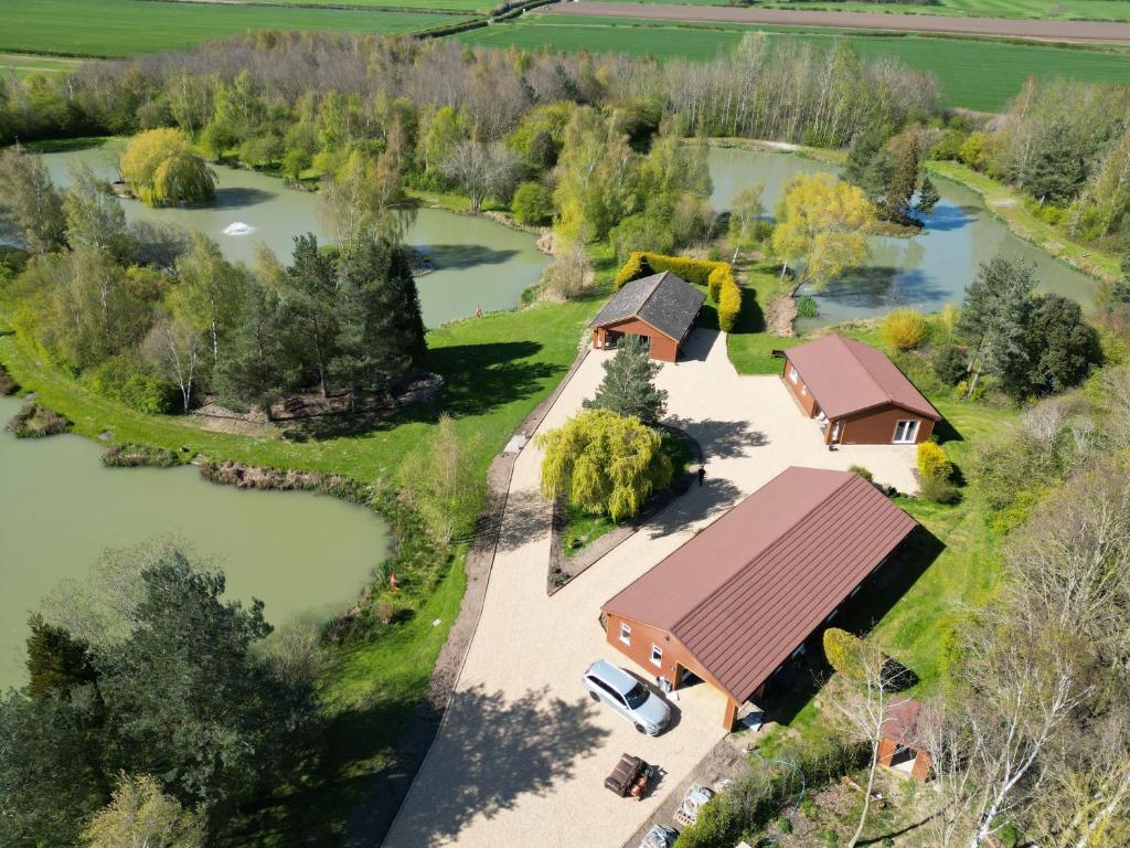 an aerial view of a house with a lake at Swallow lodge in Lincolnshire