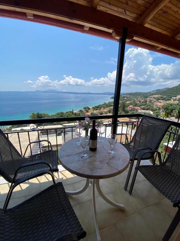 a table with wine glasses on top of a balcony at Emilios see view Apartment in Barbati