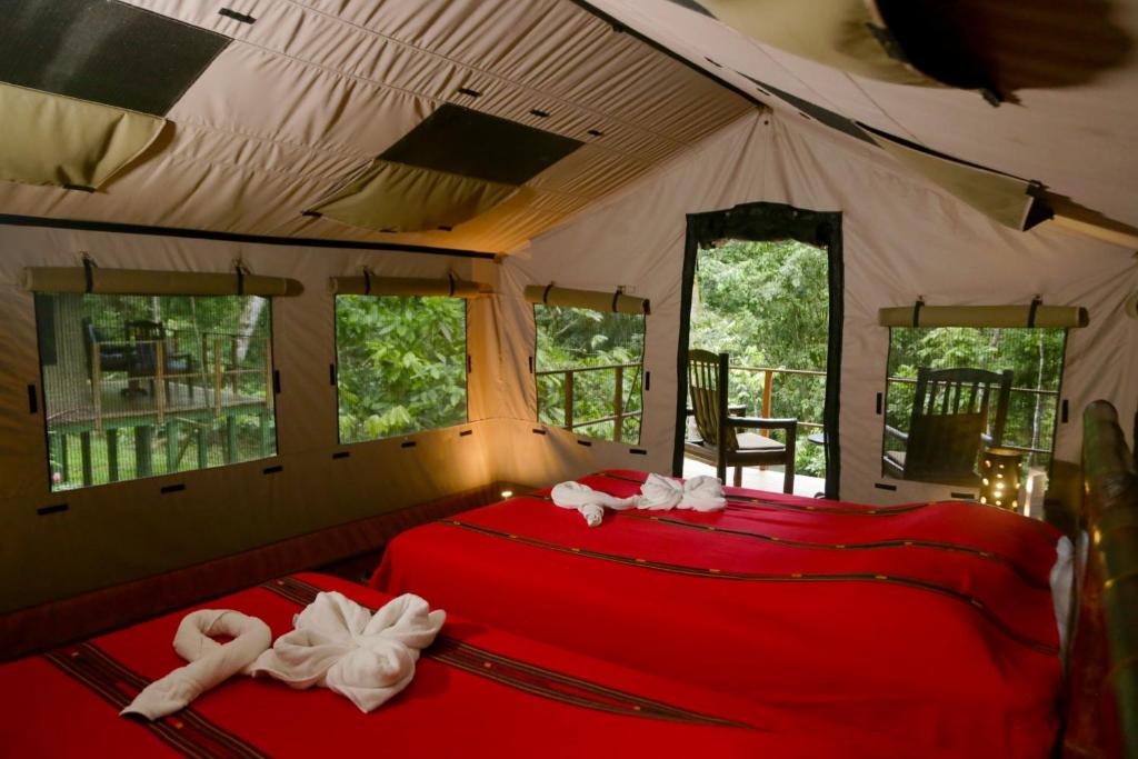 um quarto com uma cama vermelha numa tenda em Rio Tico Safari Lodge em Punta Mala