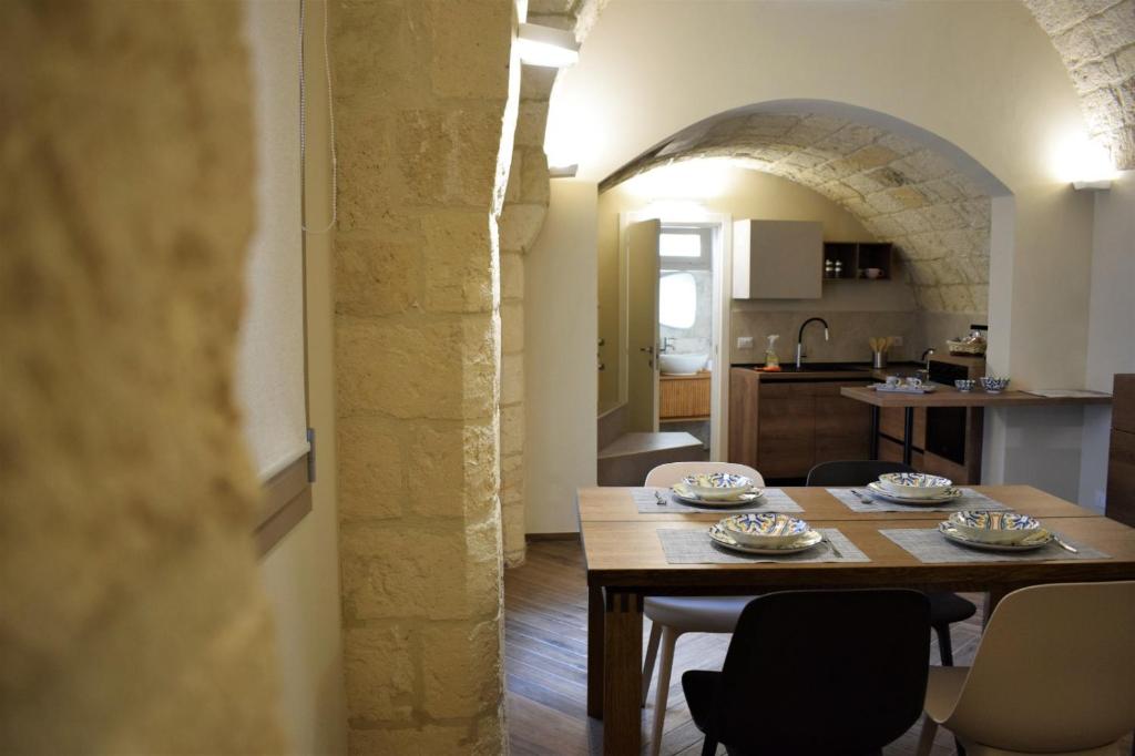 een eetkamer en een keuken met een tafel en stoelen bij Antica Dimora Santa Sofia in Nardò