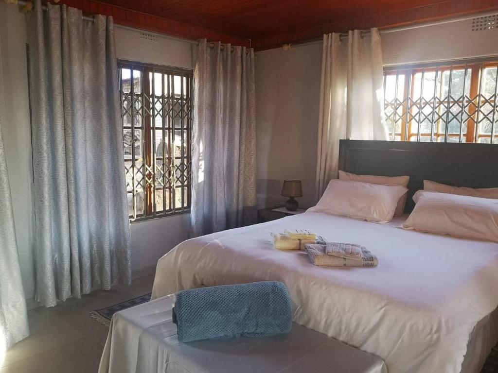 - une chambre avec un grand lit et 2 serviettes dans l'établissement Nakhah Guesthouse - Private Exterior, à Witbank