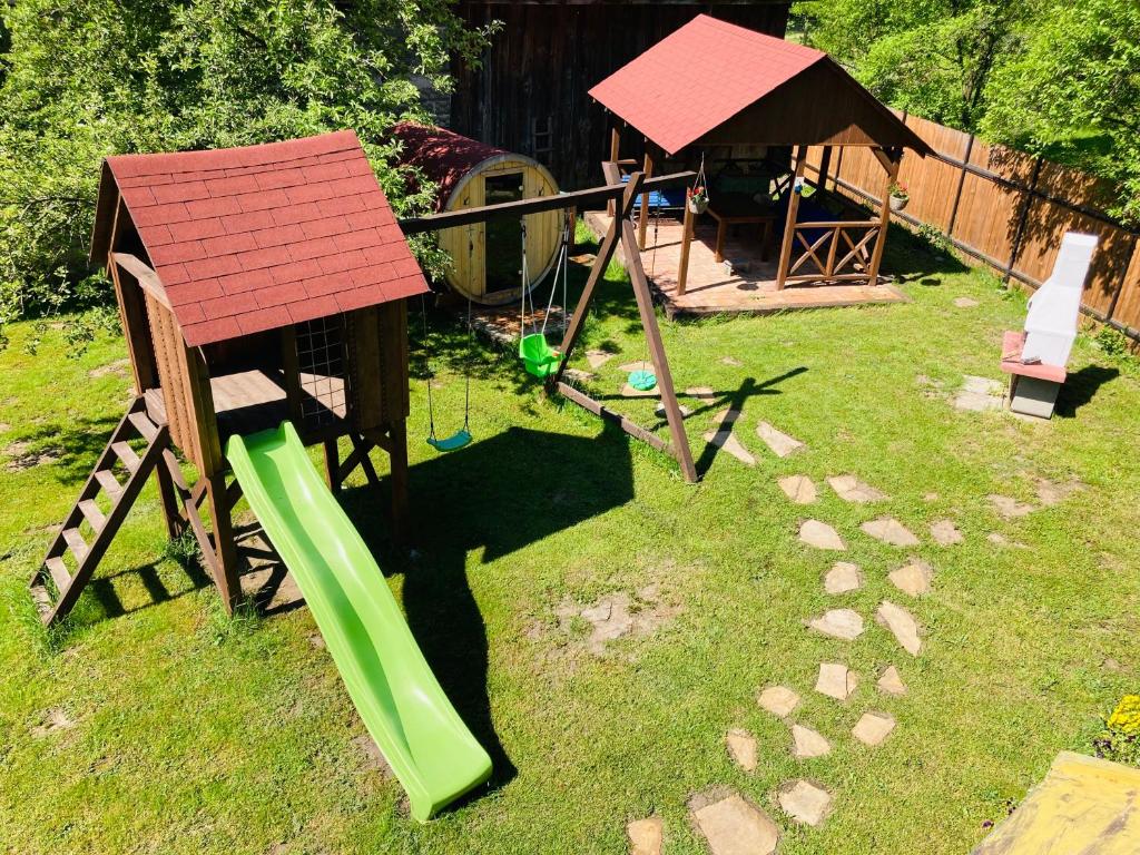 un pequeño parque infantil con una pequeña casa y un columpio en Chalupa Spoko Liptov, en Trstené