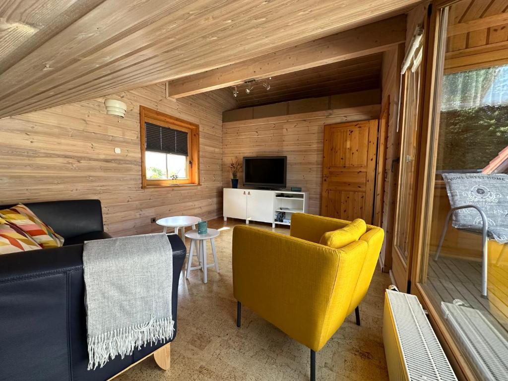 ein Wohnzimmer mit einem gelben Sofa und einem Tisch in der Unterkunft FeWo Wardersee 