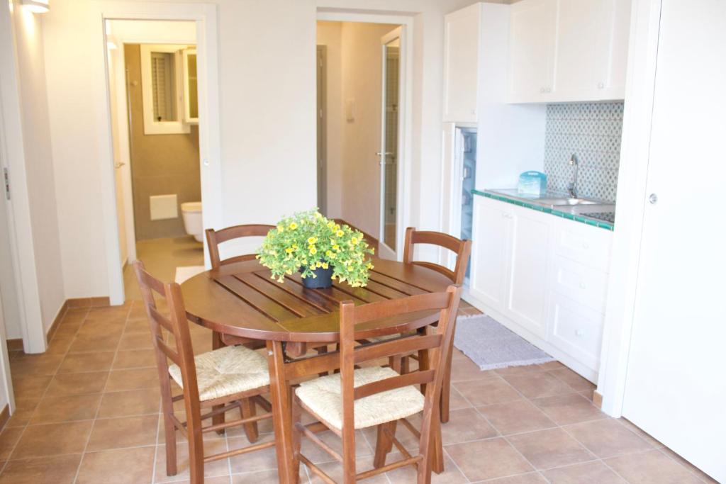 a kitchen and dining room with a wooden table and chairs at Le Casette a Favignana in Favignana