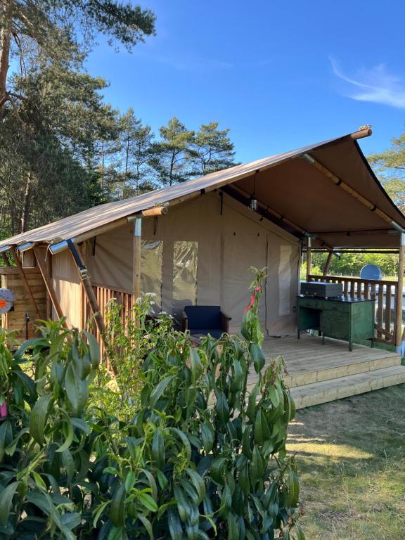 a tent with a deck in a yard at Glampingzelt Heide - Lodge in Soltau