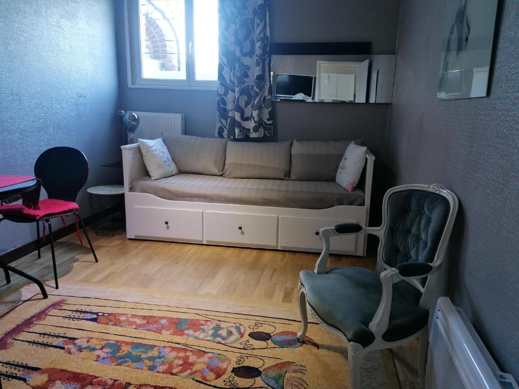 uma sala de estar com um sofá e uma cadeira em Charmant Appartement 10mn Rouen em Franqueville-Saint-Pierre