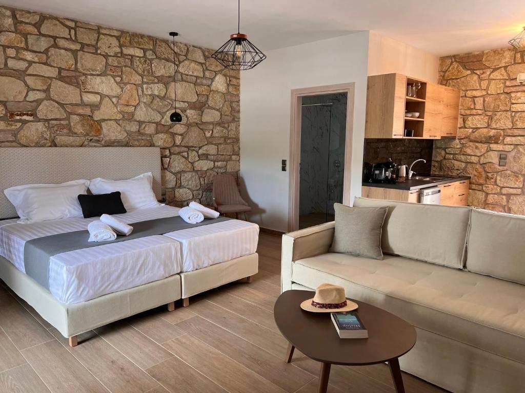 um quarto com uma cama, um sofá e uma mesa em Michelangelo suites and apartments em Valanidorachi