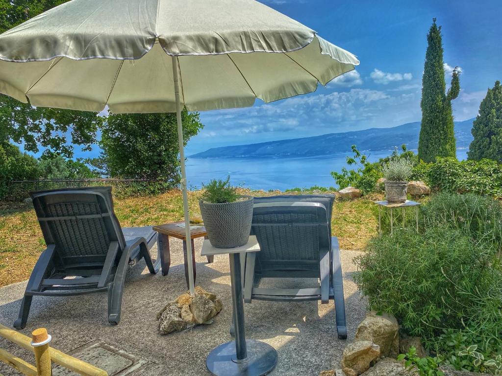 two chairs and a table with an umbrella at Holiday Home Istra in Plomin